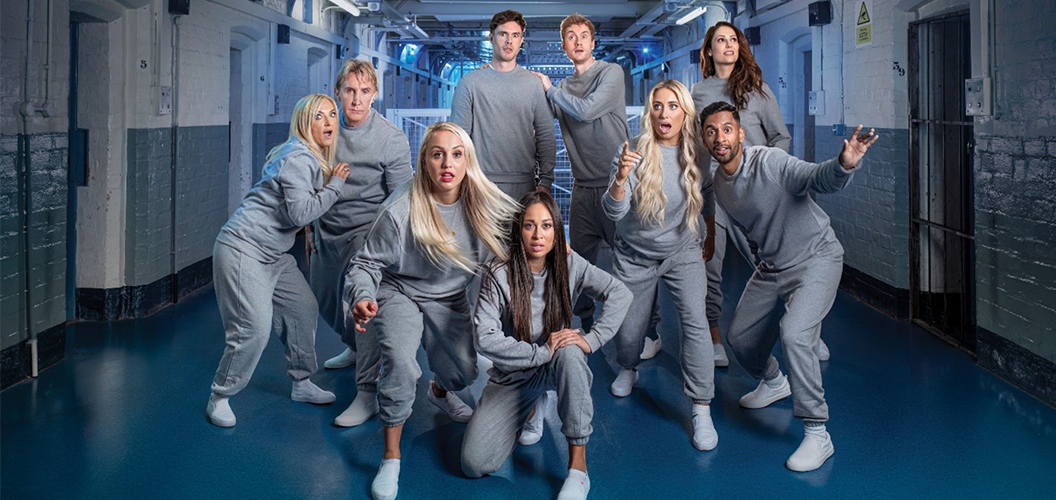 The 2022 cast of the TV show Celebrity Hunted in prison uniform, in a prison.