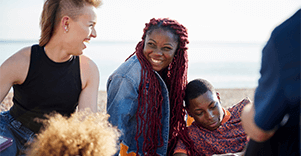 A group of friends laughing on a beach.