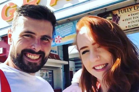 Daniel and becca taking a selfie in front of a restaurant on a sunny day.