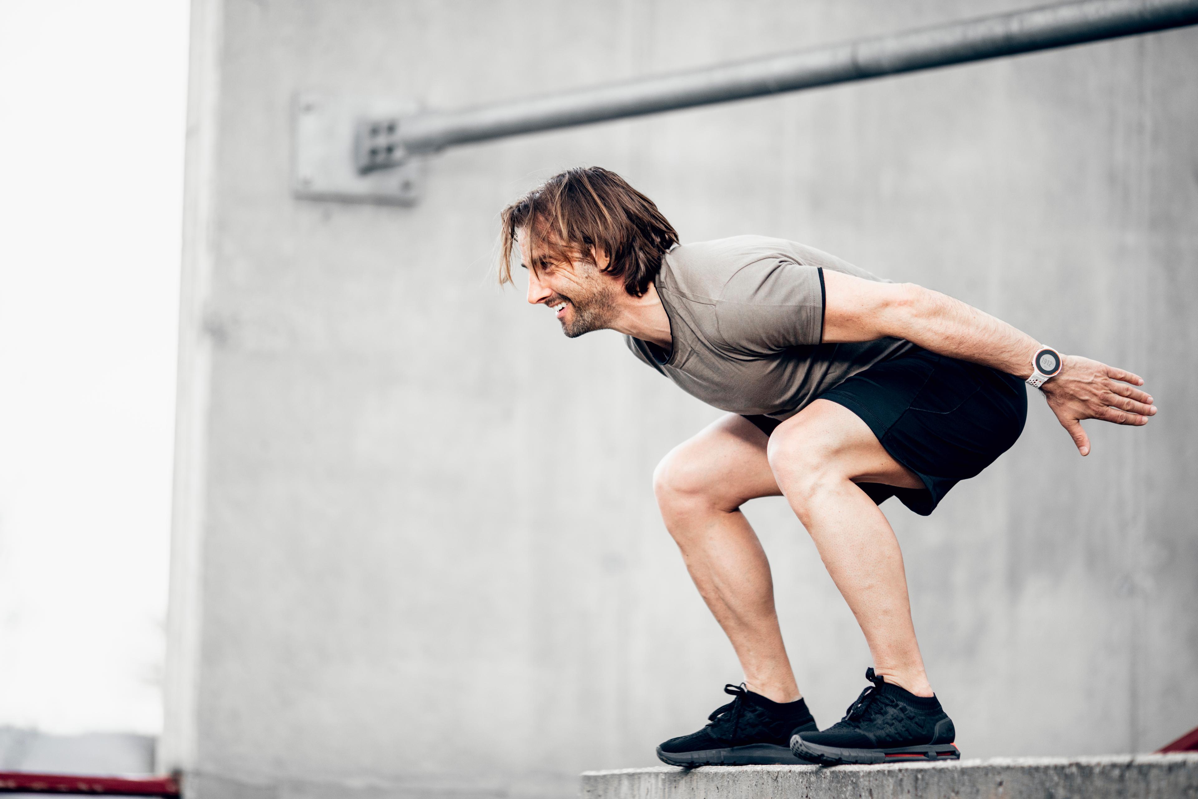 Image of a man doing a squat outdoors.