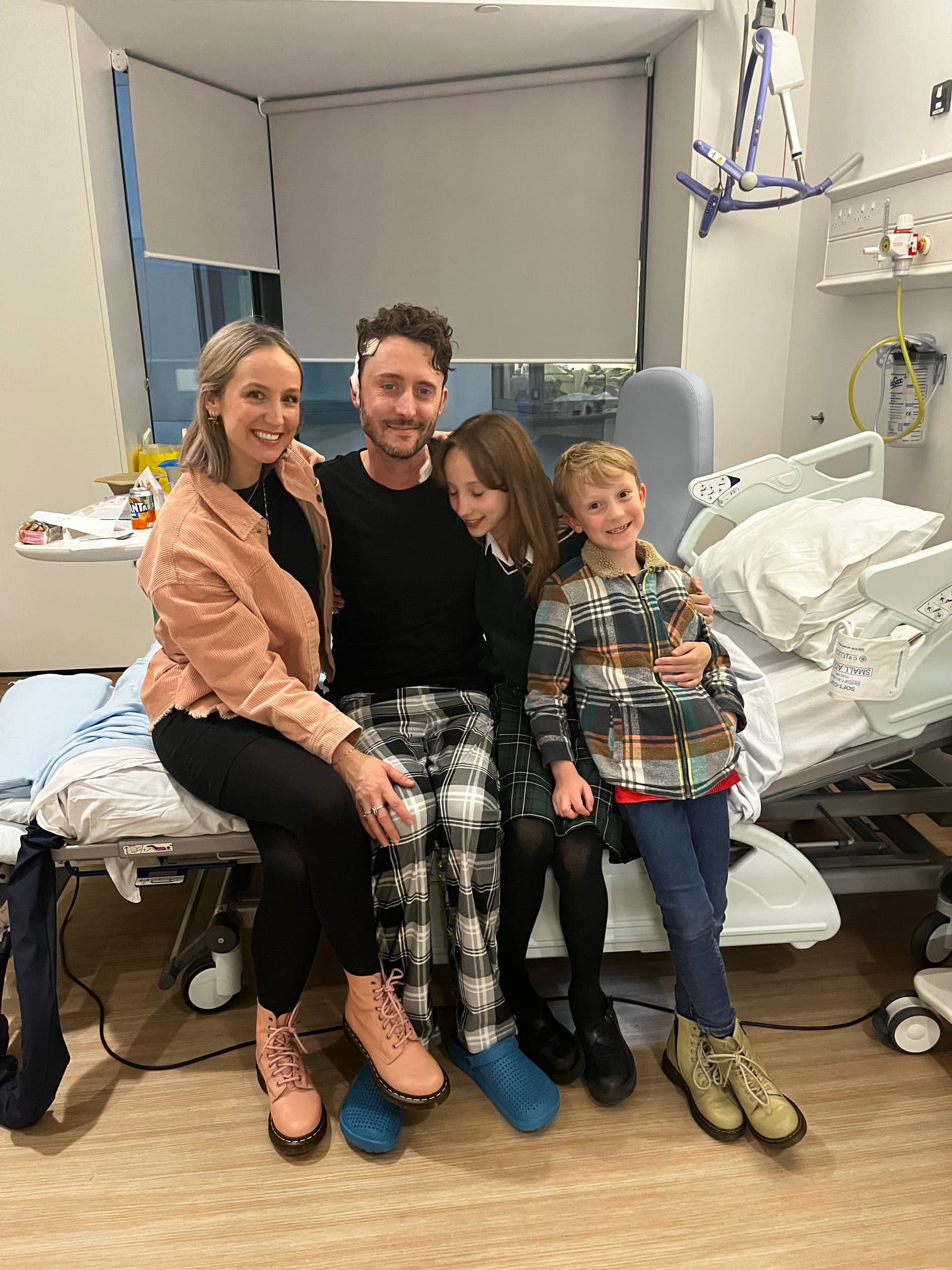 Image of Matthew in hospital with family.